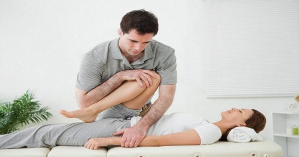 blog picture of a lady having her leg stretched by a chiropractor