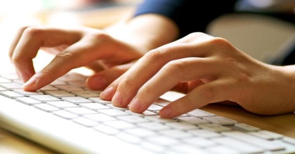 blog picture of pair of hands at a desk top keyboard
