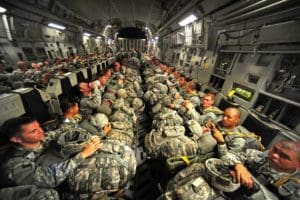blog picture of soldiers on a plane with all their equipment in their laps