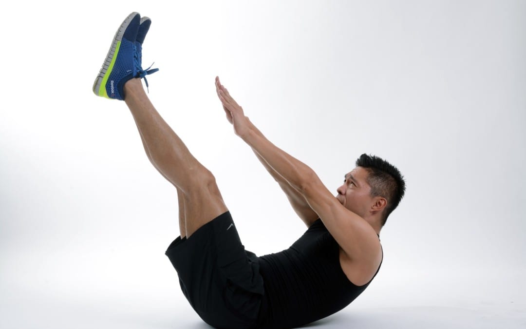 blog picture of man laying on back with legs raised arms stretching towards feet