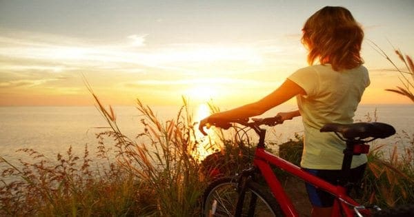 blog picture of lady bike riding in the hills looking out at the sunset