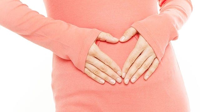 Immagine di una persona che tiene lo stomaco segnalando la regolazione nutrizionale per la malattia infiammatoria intestinale.