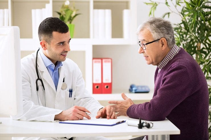 Image of an older patient discussing his neuropathy signs and symptoms for diagnosis with a doctor.
